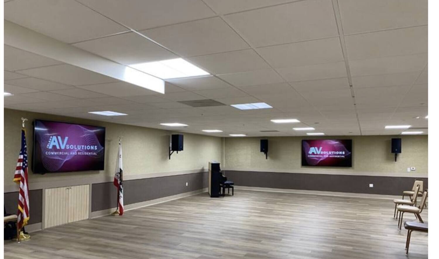 Dual commercial displays mounted in a community multipurpose room, supplied and installed by Inland AV Solutions