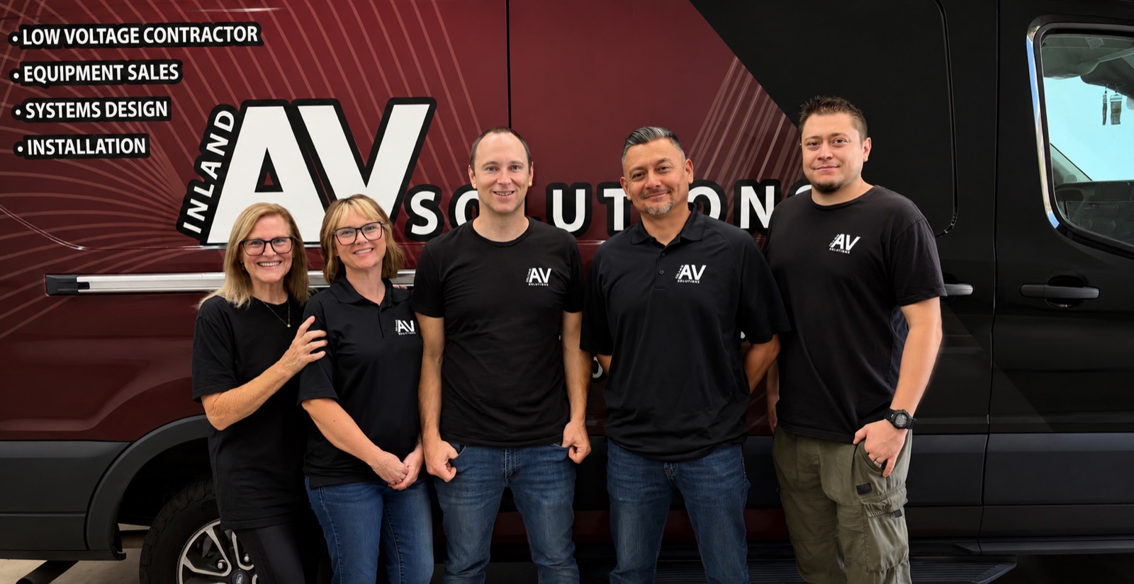 The Inland AV Solutions team standing together in front of a branded company van